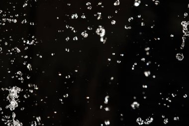 İçinde karanlık bir uçuş, ufuk bokeh su damlaları ile su sıçrama.