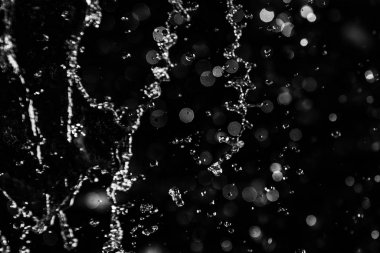 İçinde karanlık bir uçuş, ufuk bokeh su damlaları ile su sıçrama.