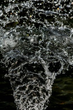 İçinde karanlık bir uçuş, ufuk bokeh su damlaları ile su sıçrama.