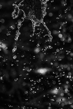 İçinde karanlık bir uçuş, ufuk bokeh su damlaları ile su sıçrama.