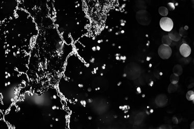 İçinde karanlık bir uçuş, ufuk bokeh su damlaları ile su sıçrama.