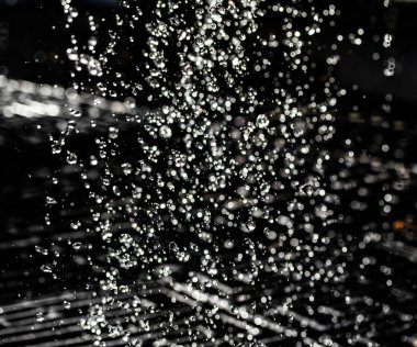 İçinde karanlık bir uçuş, ufuk bokeh su damlaları ile su sıçrama.