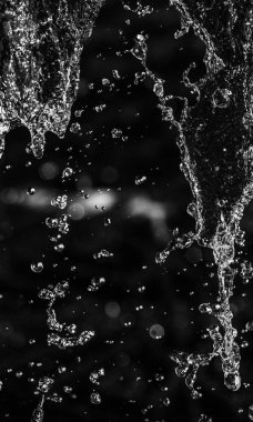 İçinde karanlık bir uçuş, ufuk bokeh su damlaları ile su sıçrama.