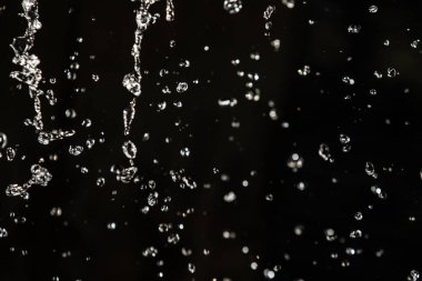 İçinde karanlık bir uçuş, ufuk bokeh su damlaları ile su sıçrama.