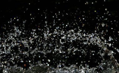 İçinde karanlık bir uçuş, ufuk bokeh su damlaları ile su sıçrama.