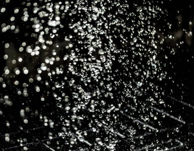 İçinde karanlık bir uçuş, ufuk bokeh su damlaları ile su sıçrama.