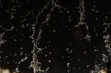 İçinde karanlık bir uçuş, ufuk bokeh su damlaları ile su sıçrama.