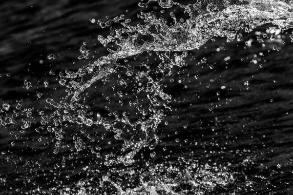 water drops in the air on a dark bokeh background