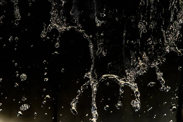 Air Memercikkan Dalam Gelap Dengan Setetes Air Terbang Bokeh Defocused — Stok Foto