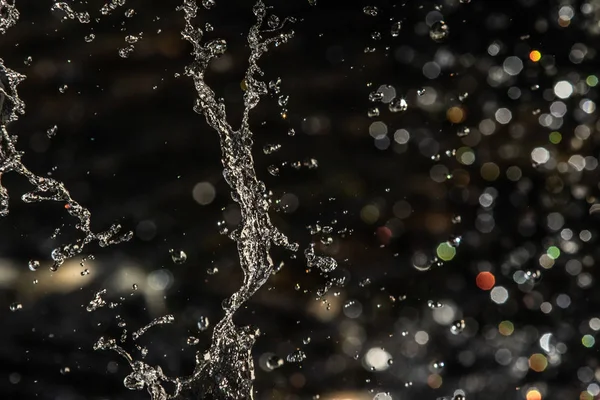 Vattenstänk Mörkret Med Droppar Vatten Flyger Oskarp Bokeh — Stockfoto