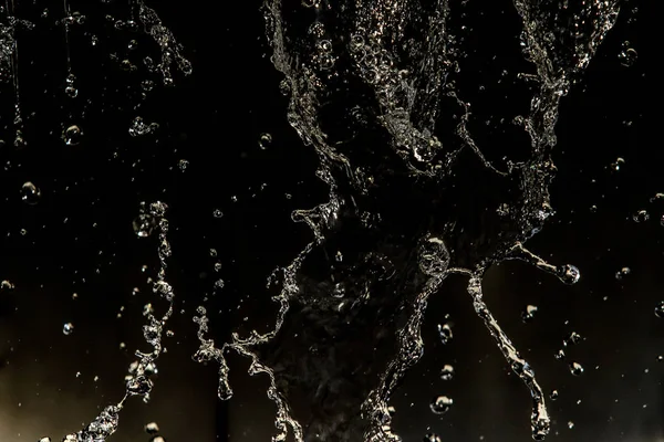 Air Memercikkan Dalam Gelap Dengan Setetes Air Terbang Bokeh Defocused — Stok Foto