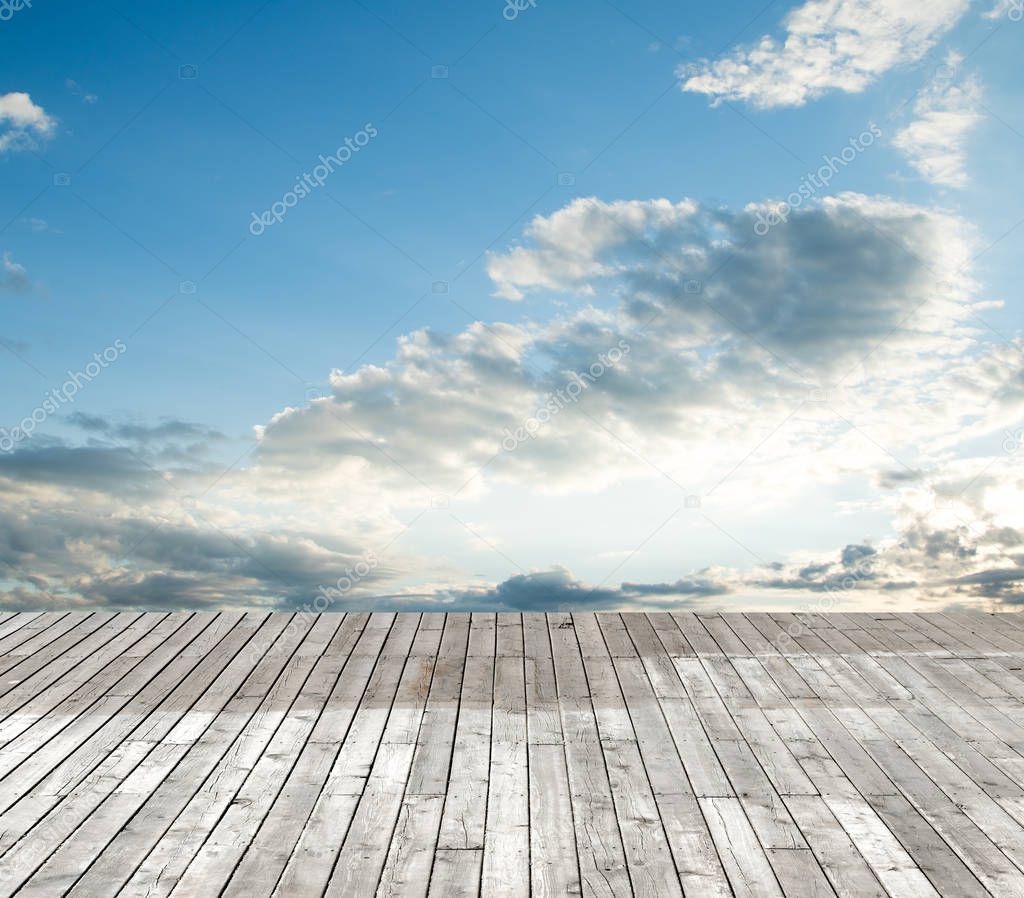 wooden floor against the sky with clouds