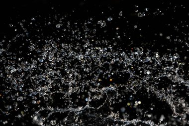 bir karanlık bokeh arka plan üstünde su damlaları