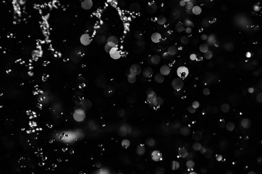 İçinde karanlık bir uçuş, ufuk bokeh su damlaları ile su sıçrama.