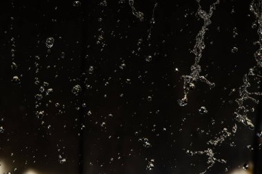 İçinde karanlık bir uçuş, ufuk bokeh su damlaları ile su sıçrama.