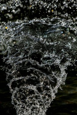 İçinde karanlık bir uçuş, ufuk bokeh su damlaları ile su sıçrama.