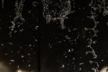 İçinde karanlık bir uçuş, ufuk bokeh su damlaları ile su sıçrama.