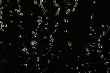 İçinde karanlık bir uçuş, ufuk bokeh su damlaları ile su sıçrama.