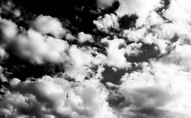 Beyaz bulutların üzerinde karanlık bir gökyüzü, tek renkli