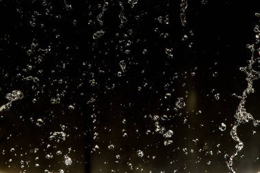 İçinde karanlık bir uçuş, ufuk bokeh su damlaları ile su sıçrama.