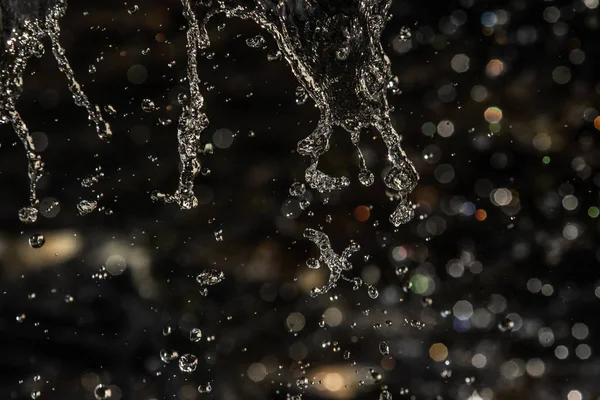 Salpicos Água Escuro Com Uma Gota Água Voando Bokeh Desfocado — Fotografia de Stock