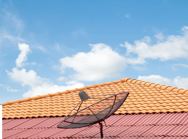 antenna on the roof of the house, the sky clouds