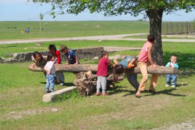 Kazakistan, Çimkent - 23 Nisan 2017. Esnek rocker. Küçük çocuk sokakta bahar yeşil çim oyun.