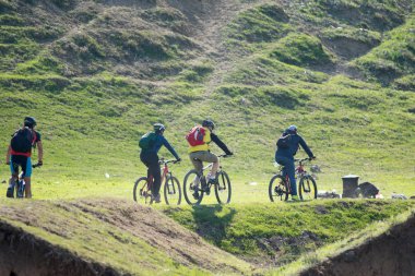 Kazakistan, Çimkent - 23 Nisan 2017. Bozkır yeşil çim bisikletçiler binmek.