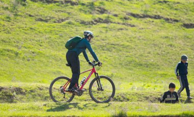 Kazakistan, Çimkent - 23 Nisan 2017. Bozkır yeşil çim bisikletçiler binmek.