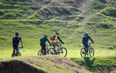 Kazakistan, Çimkent - 23 Nisan 2017. Bozkır yeşil çim bisikletçiler binmek.