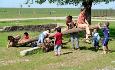 Kazakistan, Çimkent - 23 Nisan 2017. Esnek rocker. Küçük çocuk sokakta bahar yeşil çim oyun.