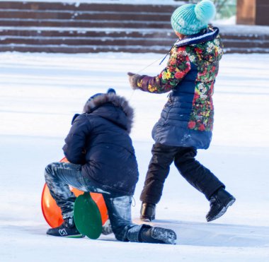 Petropavlovsk, Kazakistan - 8 Ocak 2019: Çocuk buzlu bir tepede binmek. Yetişkinler ve çocuklar parkta birlikte sakin ol.