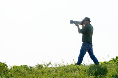 Shymkent, Kazakistan - 04 Mayıs 2017: kamera ile adam manzara vuruyor. Yeşil çimen, beyaz arka plan.