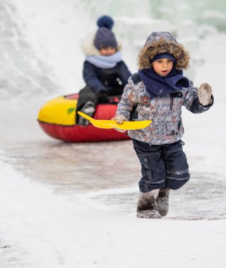 Petropavlovsk, Kazakistan - 13 Ocak 2019: Çocuk buzlu bir tepede binmek. Yetişkinler ve çocuklar parkta birlikte sakin ol.