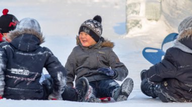 Petropavlovsk, Kazakistan - 8 Ocak 2019: Çocuk buzlu bir tepede binmek. Yetişkinler ve çocuklar parkta birlikte sakin ol.