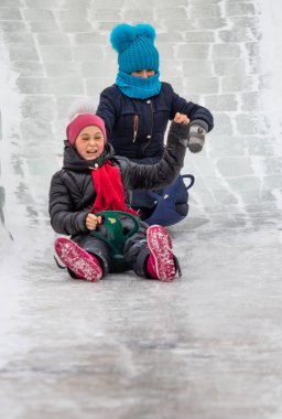 Petropavlovsk, Kazakistan - 13 Ocak 2019: Çocuk buzlu bir tepede binmek. Yetişkinler ve çocuklar parkta birlikte sakin ol.