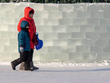 Petropavlovsk, Kazakistan - 8 Ocak 2019: Çocuk buzlu bir tepede binmek. Yetişkinler ve çocuklar parkta birlikte sakin ol.
