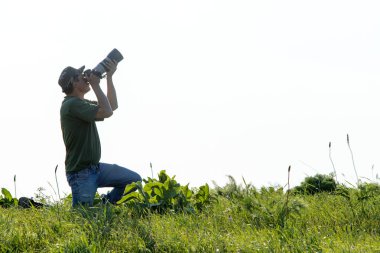 Shymkent, Kazakistan - 04 Mayıs 2017: kamera ile adam manzara vuruyor. Yeşil çimen, beyaz arka plan.