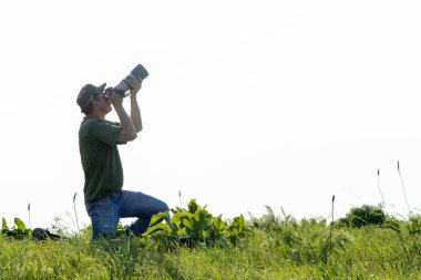 Shymkent, Kazakistan - 04 Mayıs 2017: kamera ile adam manzara vuruyor. Yeşil çimen, beyaz arka plan.