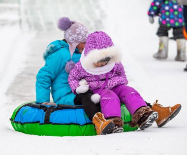 Petropavlovsk, Kazakistan - 13 Ocak 2019: Çocuk buzlu bir tepede binmek. Yetişkinler ve çocuklar parkta birlikte sakin ol.