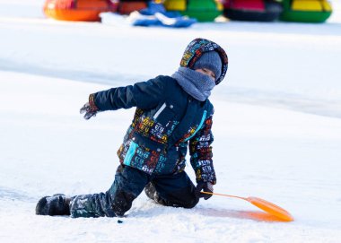 Petropavlovsk, Kazakistan - 9 Ocak 2019: Çocuk buzlu bir tepede binmek. Yetişkinler ve çocuklar parkta birlikte sakin ol.