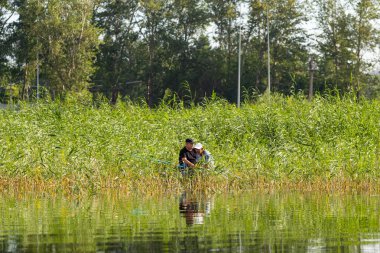 Petropavlovsk, Kazakistan - 28 Temmuz 2018: İnsanlar göl kenarında lastik gemilerde balıkçılar, balık. Lake Pestroe, Petropavlovsk, Kazakistan.