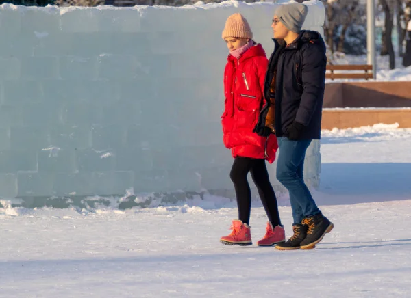 Petropavlovsk, Kazakistan - 8 Ocak 2019: Çocuk buzlu bir tepede binmek. Yetişkinler ve çocuklar parkta birlikte sakin ol.