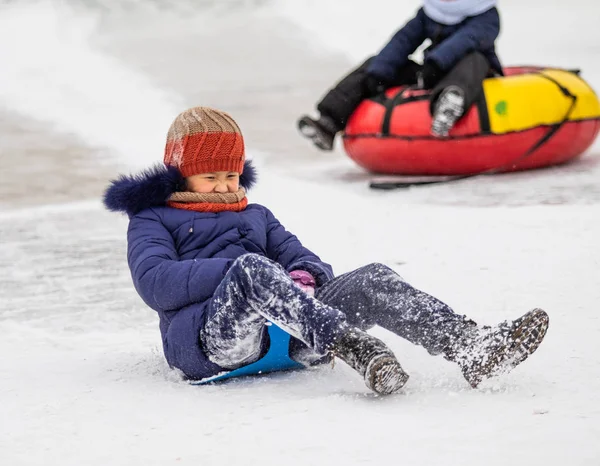 Petropavlovsk, Kazakistan - 13 Ocak 2019: Çocuk buzlu bir tepede binmek. Yetişkinler ve çocuklar parkta birlikte sakin ol.