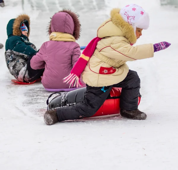 Petropavlovsk, Kazakistan - 13 Ocak 2019: Çocuk buzlu bir tepede binmek. Yetişkinler ve çocuklar parkta birlikte sakin ol.