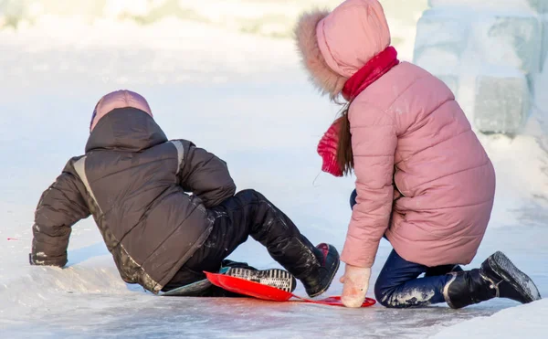Petropavlovsk, Kazakistan - 8 Ocak 2019: Çocuk buzlu bir tepede binmek. Yetişkinler ve çocuklar parkta birlikte sakin ol.