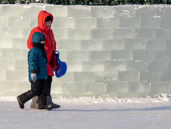Petropavlovsk, Kazakistan - 8 Ocak 2019: Çocuk buzlu bir tepede binmek. Yetişkinler ve çocuklar parkta birlikte sakin ol.