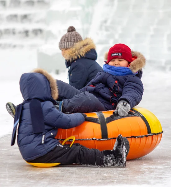 Petropavlovsk, Kazakistan - 13 Ocak 2019: Çocuk buzlu bir tepede binmek. Yetişkinler ve çocuklar parkta birlikte sakin ol.