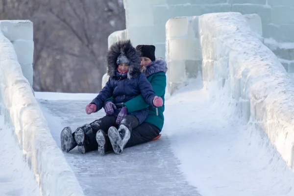 Petropavlovsk, Kazakistan - 8 Ocak 2019: Çocuk buzlu bir tepede binmek. Yetişkinler ve çocuklar parkta birlikte sakin ol.