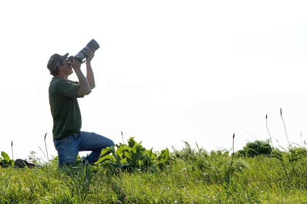 Shymkent, Kazakistan - 04 Mayıs 2017: kamera ile adam manzara vuruyor. Yeşil çimen, beyaz arka plan.